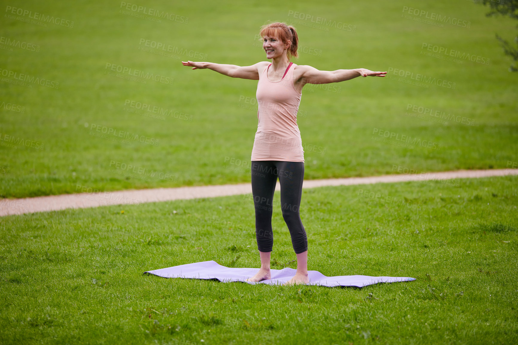 Buy stock photo Shot of a woman doing yoga in the park