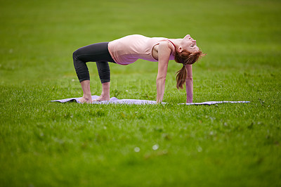 Buy stock photo Shot of a woman doing yoga in the park