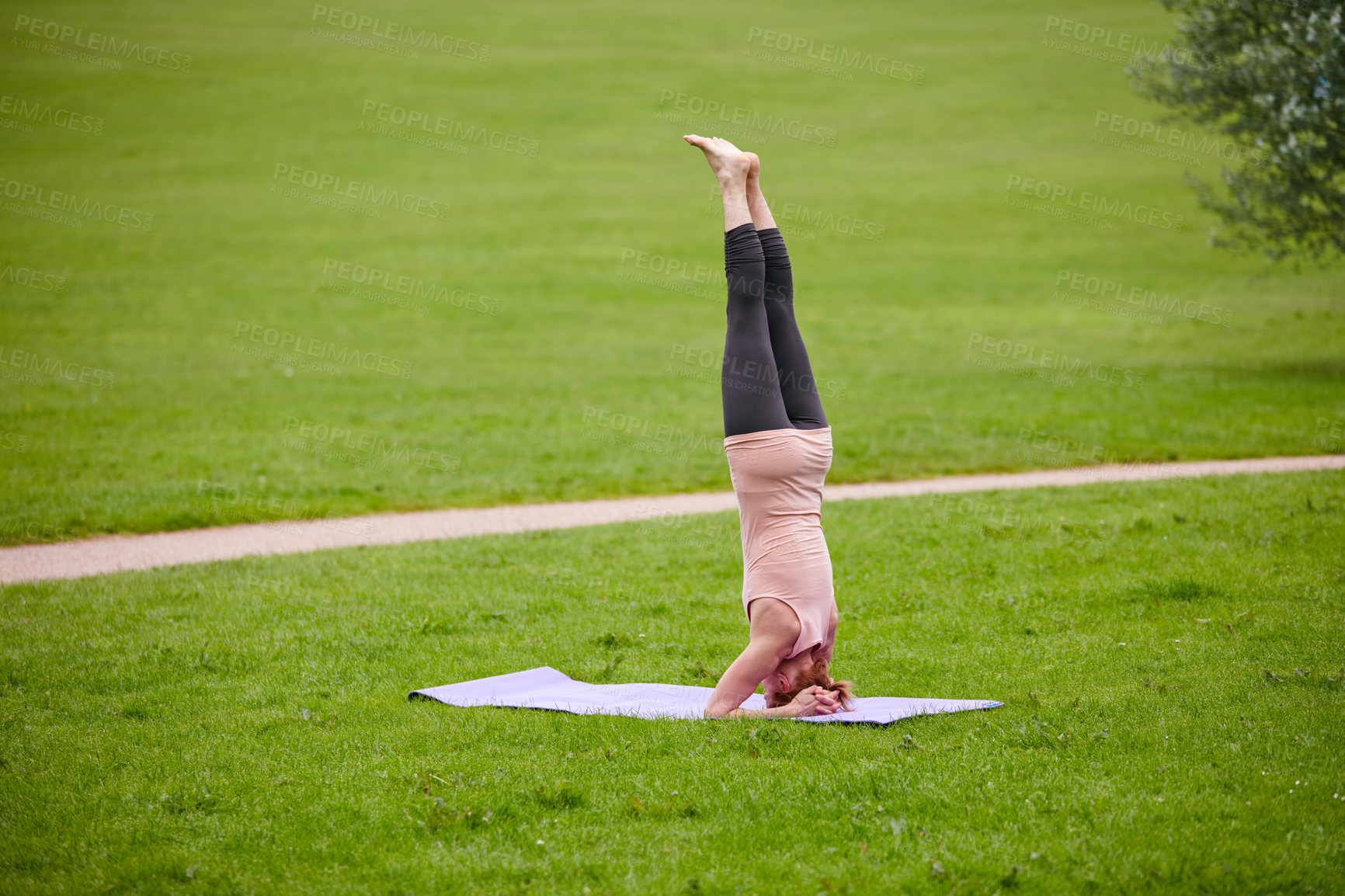 Buy stock photo Shot of a woman doing yoga in the park