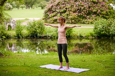 Buy stock photo Shot of a woman doing yoga in the park