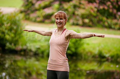 Buy stock photo Shot of a woman practicing yoga in a park