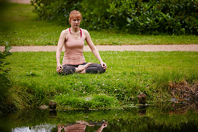 Buy stock photo Shot of a woman sitting in the lotus position in the park