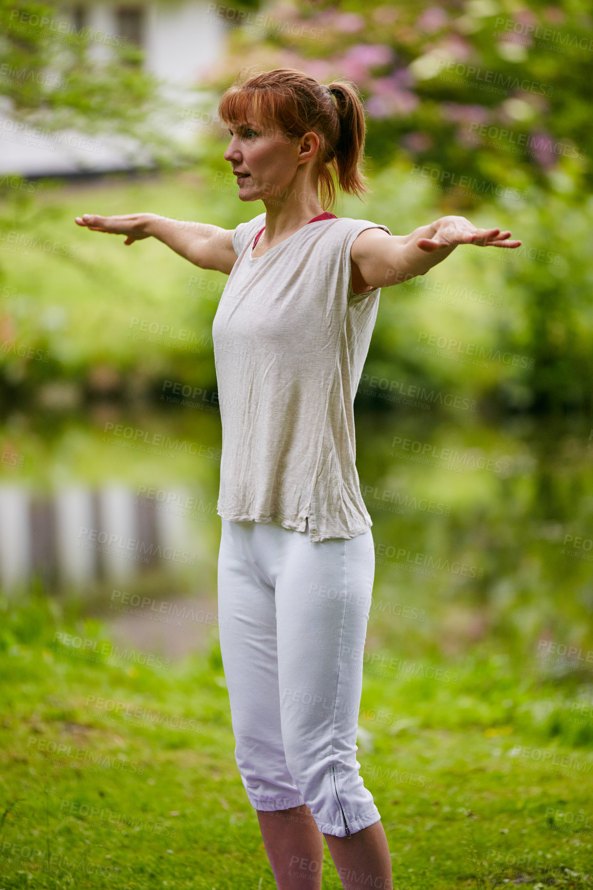 Buy stock photo Shot of a woman doing yoga in the park