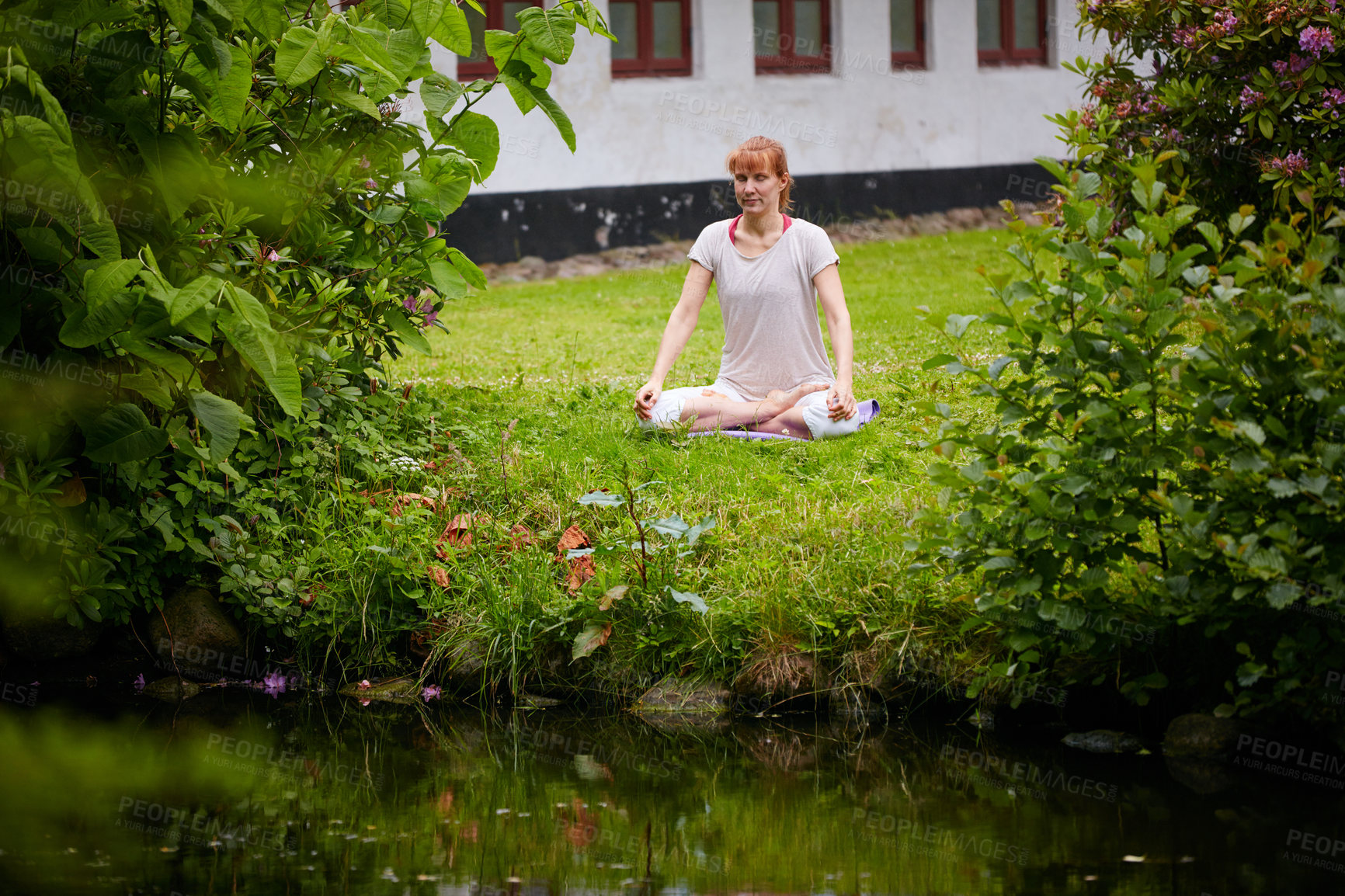 Buy stock photo Shot of a woman sitting in the lotus position in her backyard