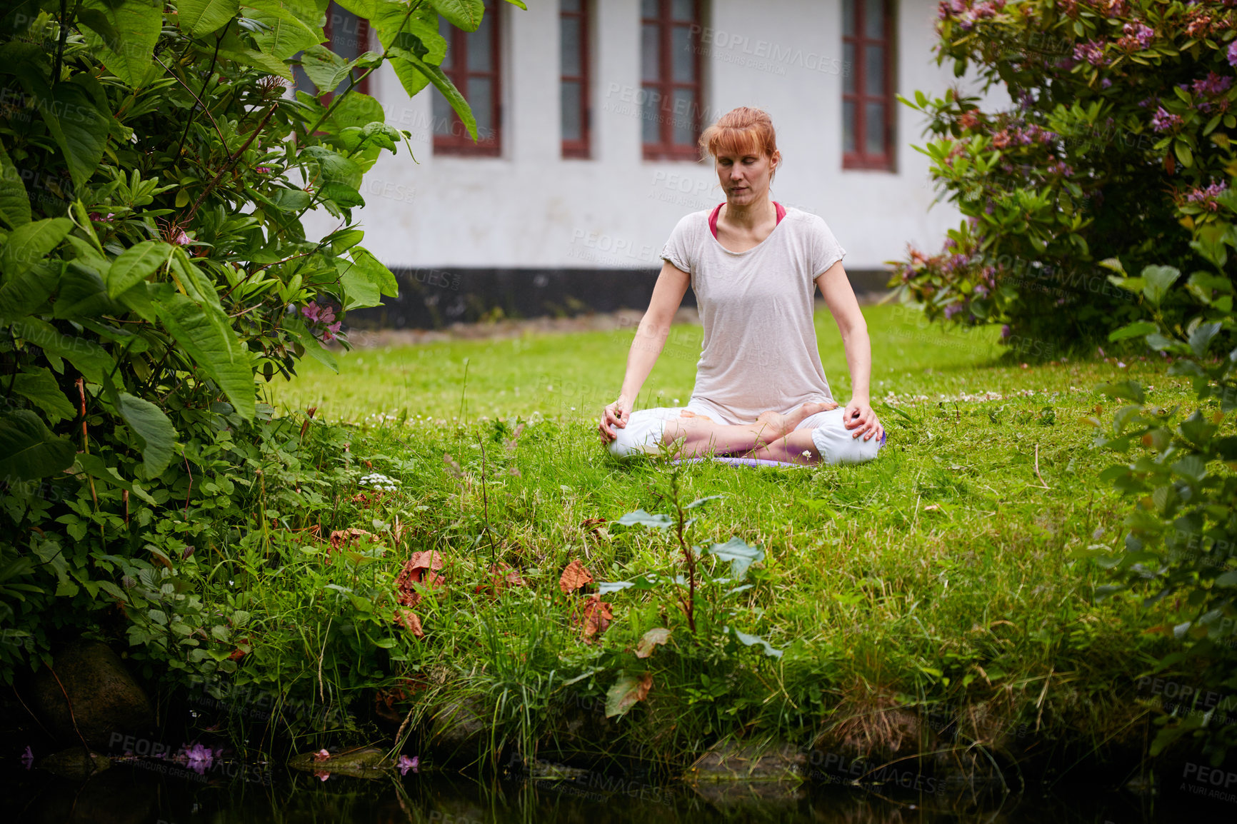 Buy stock photo Shot of a woman sitting in the lotus position in her backyard