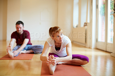 Buy stock photo Shot of two people doing yoga together in a studio