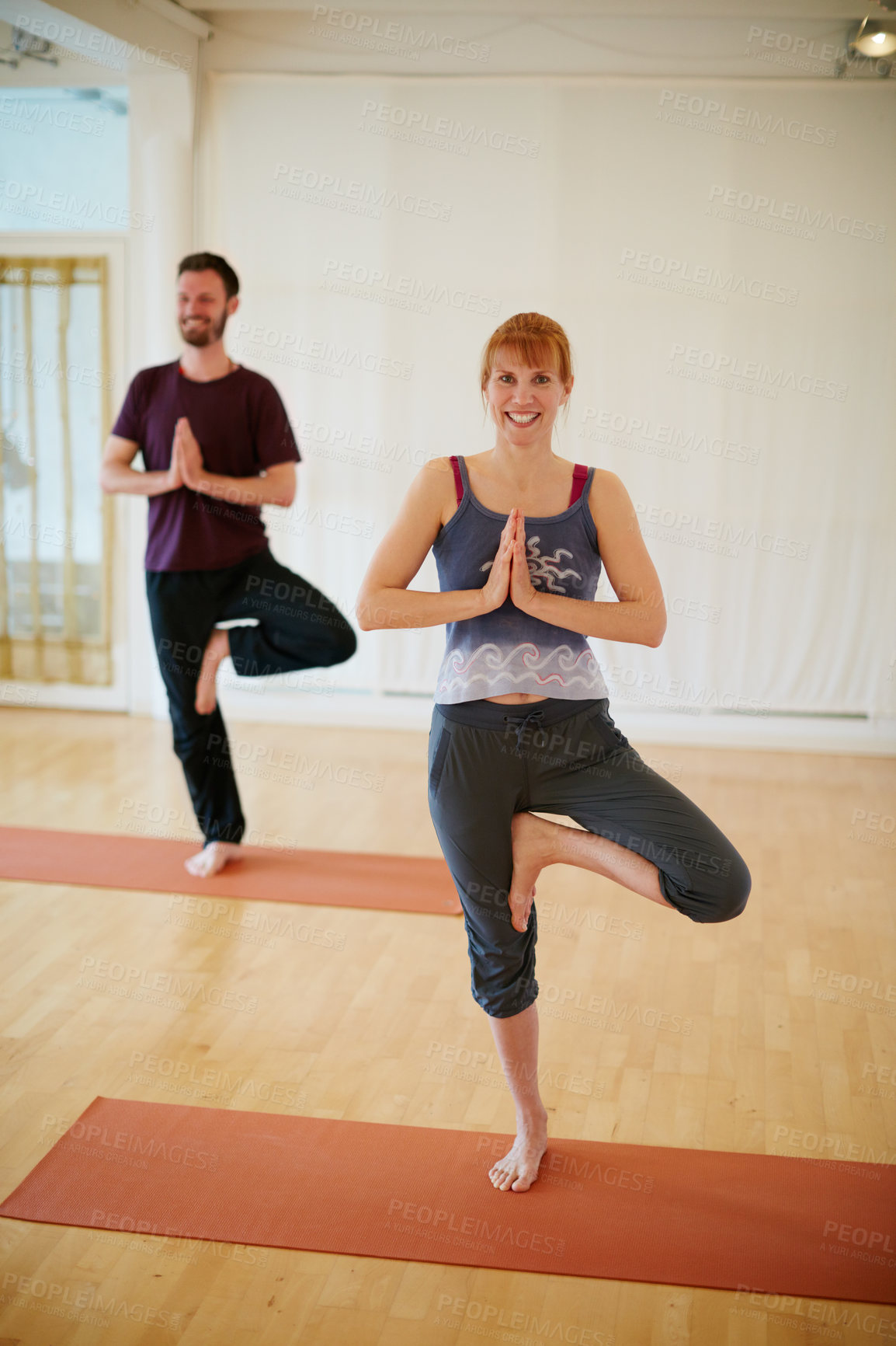 Buy stock photo Shot of two people doing yoga together in a studio