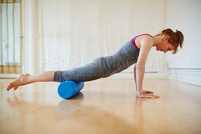 Buy stock photo Shot of a woman doing roller foam exercises during a yoga workout