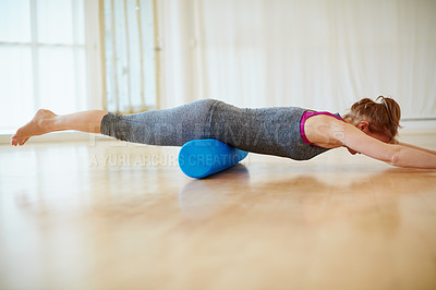 Buy stock photo Shot of a woman doing roller foam exercises during a yoga workout