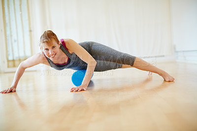 Buy stock photo Shot of a woman doing roller foam exercises during a yoga workout