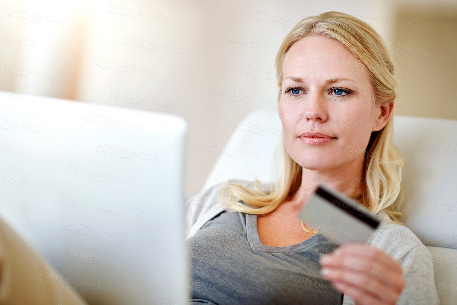 Buy stock photo Shot of a woman doing some online shopping on her sofa at home