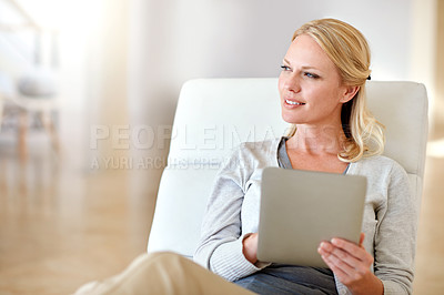 Buy stock photo Shot of a woman using a digital tablet in the living room