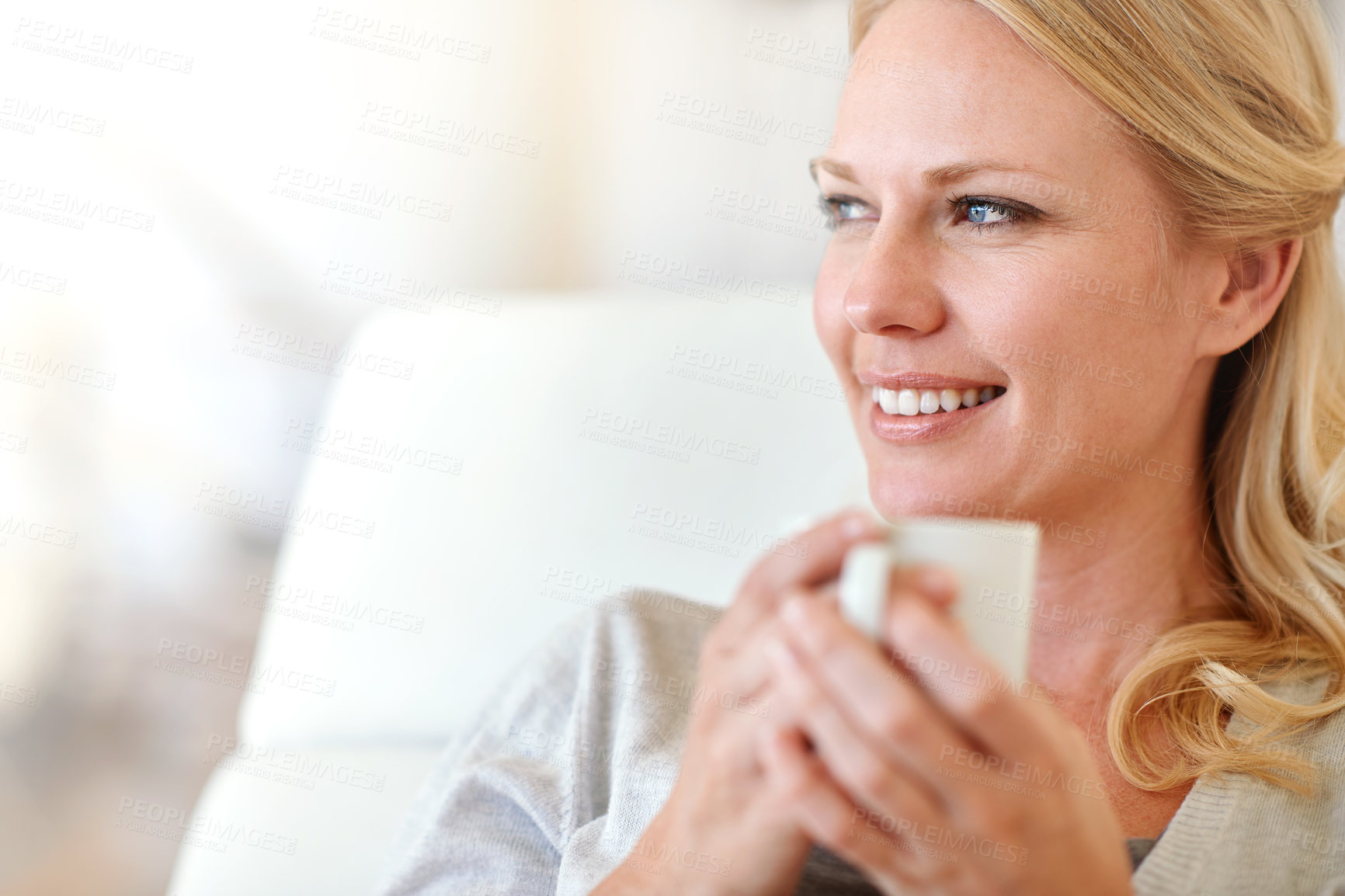 Buy stock photo Shot of a woman enjoying a cup of coffee at home