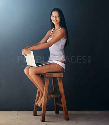 Buy stock photo Laptop, portrait and woman on chair to relax in studio with gray wall background for social media. Computer, smile and underwear with happy young person sitting on stool for blogging or streaming
