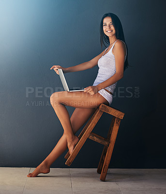 Buy stock photo Laptop, portrait and woman on chair in studio with gray wall background for social media. Computer, relax and underwear with happy young person leaning or rocking on stool for blogging or streaming