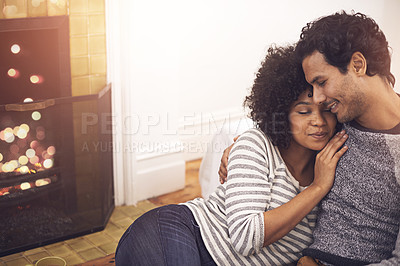 Buy stock photo Couple, fireplace and love in embrace, home and peace or calm and proud of marriage or commitment. People, romance and hugging on floor in living room on weekend, support and trust in relationship