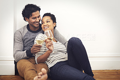 Buy stock photo Couple, floor and wine for toast and embrace in home, smile and proud of marriage and commitment. People, milestone and drinking in living room on weekend, support and celebration for relationship