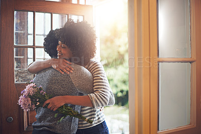 Buy stock photo Love, hug and couple with flowers, gift and happiness with romance, bonding and anniversary. Partners, man or happy woman embrace, floral present or bouquet with joy, romantic and celebration at home