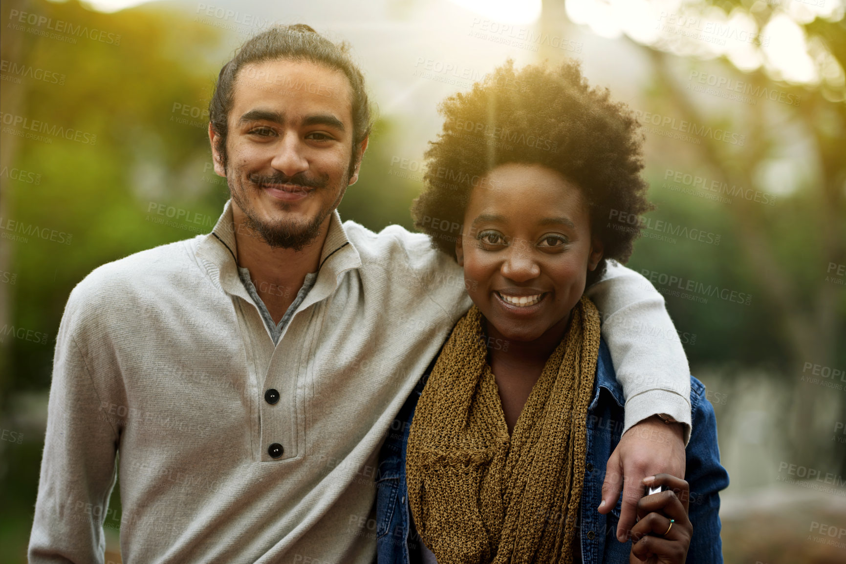 Buy stock photo Park, portrait and happy interracial couple together with trees, sunshine and morning embrace with love. Romance, smile and date in nature, man and woman hug with diversity, connection and care.