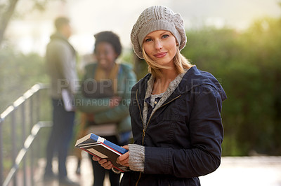 Buy stock photo Closeup, winter and university student with book in outdoor on campus, happy and smile with support and care. Education, college with notes to prepare for exam, assessment and texbook to study. 