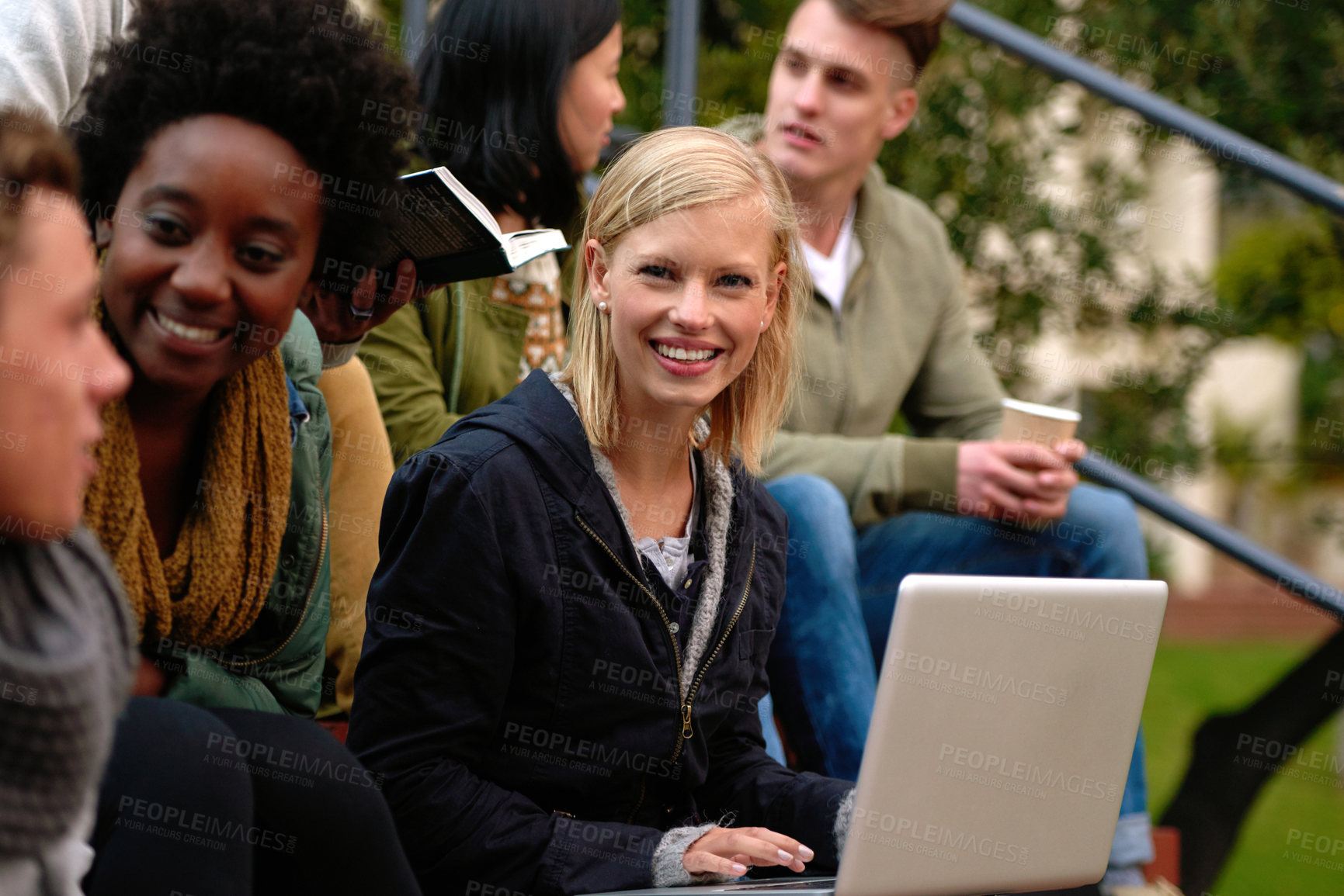 Buy stock photo Woman, university student with laptop and outdoor on campus, smile and research to study for exams. Diverse group, college and information for learning and share notes for test or assignment deadline