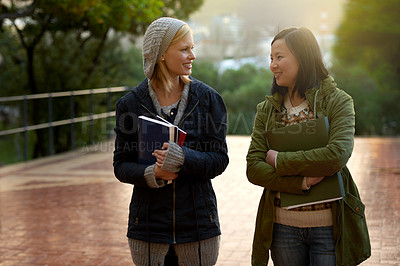Buy stock photo Students, women and friends on campus for university, conversation while walking to class and smile outdoor. College, communication and books for studying, education and academic growth with talk