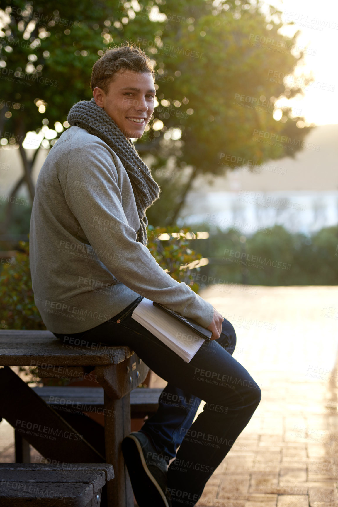 Buy stock photo Student, man and outdoor on campus with book in smile, study and prepare for exam with revision notes. Portrait, college and academic for assignment with textbook for education and learning.