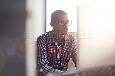 Buy stock photo Serious, thinking and creative man working on his computer while doing research and reading about innovation. Dedicated web designer giving attention while working on creative project on desktop pc 
