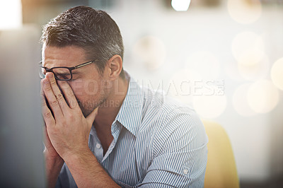 Buy stock photo Cropped shot of a stressed businessman sitting at his desk