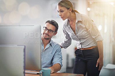 Buy stock photo Cropped shot of two colleagues working together on a computer