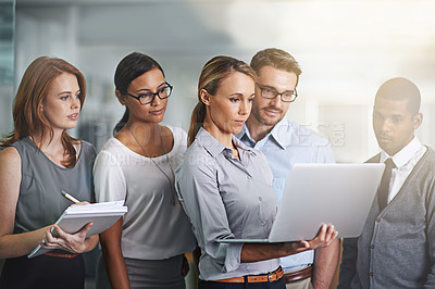 Buy stock photo Shot of a business team working on a laptop together