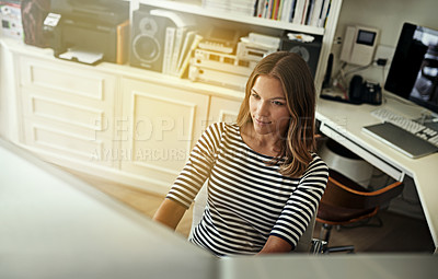Buy stock photo Shot of a young woman working on a computer in her home office