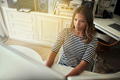 Buy stock photo High angle shot of a young woman working on a computer in her home office