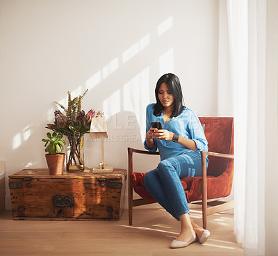 Buy stock photo Woman, texting and living room with smartphone on chair for relax with social media with reading in home. Mobile, talk and research with politics for voting with concern for ballots with news