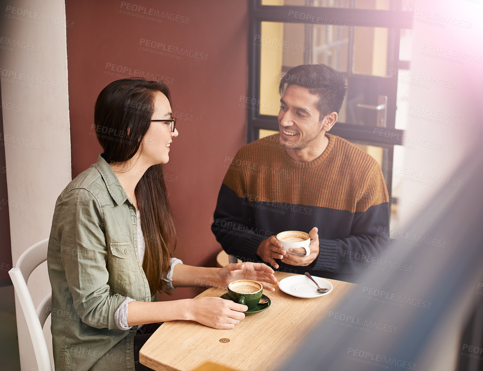 Buy stock photo Coffee shop, morning and couple on date with drink in conversation, talking and chatting for bonding. Love, happy and man and woman with caffeine, cappuccino or beverage in restaurant, cafe and store