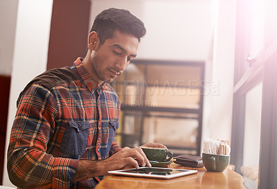 Buy stock photo Man, tablet and typing with coffee for research, social media or online browsing at cafe. Male person or freelancer working on technology for search, scrolling or networking in communication at shop