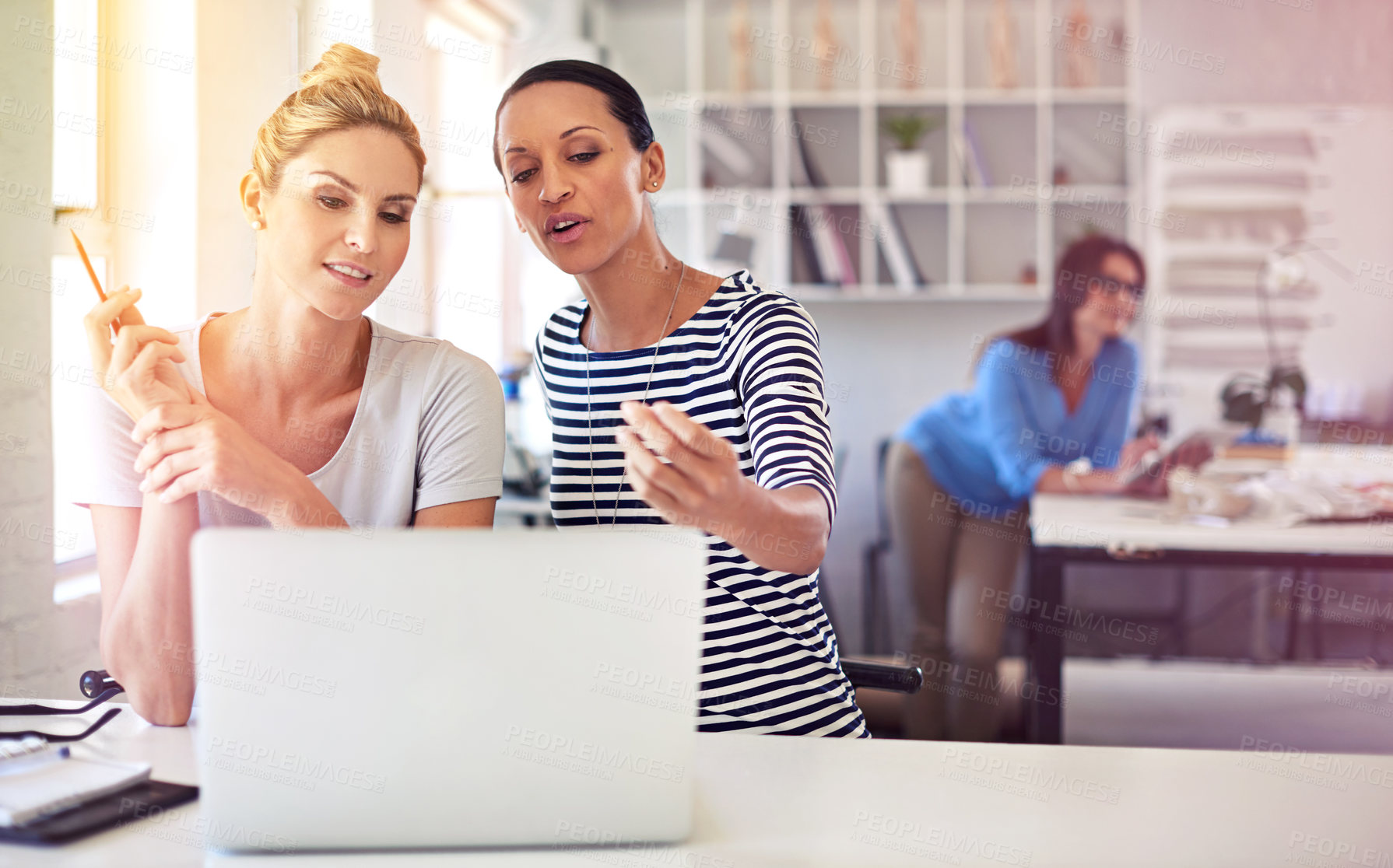 Buy stock photo Shot of two coworkers using a laptop together in a boutique