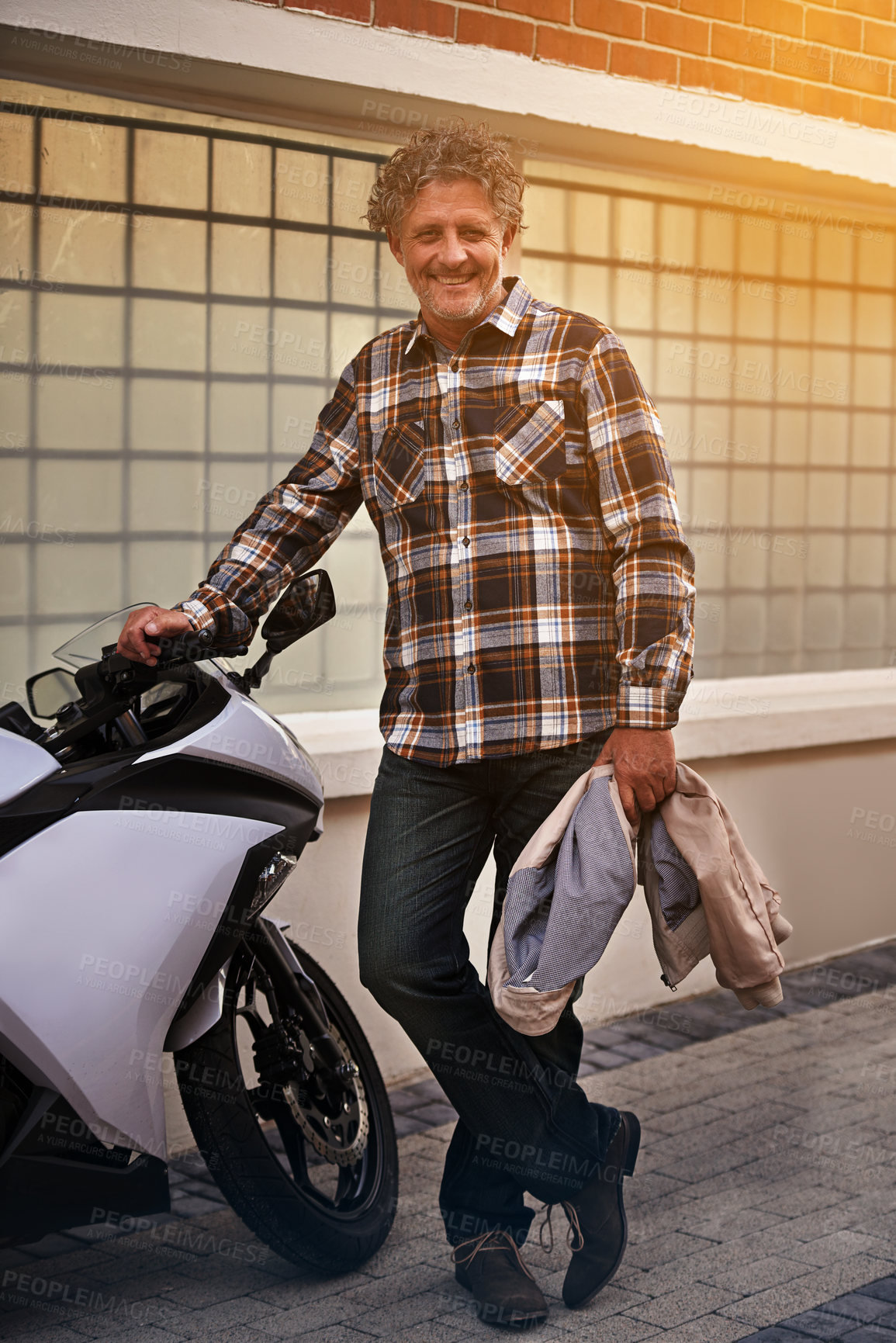 Buy stock photo Mature, man and portrait with motorbike in city or travel journey for weekend trip, downtown or commute. Male person, face and transportation on sidewalk for urban New York, relax or holiday vacation