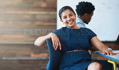 Buy stock photo A young businesswoman sitting in an office chair with a colleague in the background