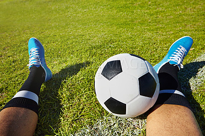 Buy stock photo POV shot of a soccer player sitting with a soccer ball on a playing field