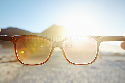 Buy stock photo POV of glasses looking into the sun at the beach. Person holding spectacle toward bright sunlight or sunshine at the sea shore. Eyewear protecting eyesight from the light outdoors at the ocean