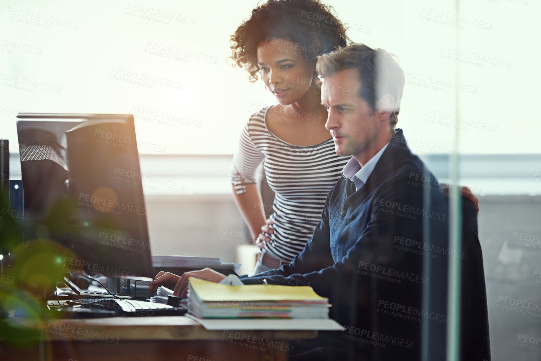 Buy stock photo Cropped shot of two colleagues working together in the office