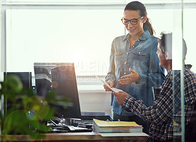 Buy stock photo Cropped shot of two colleagues working together in the office