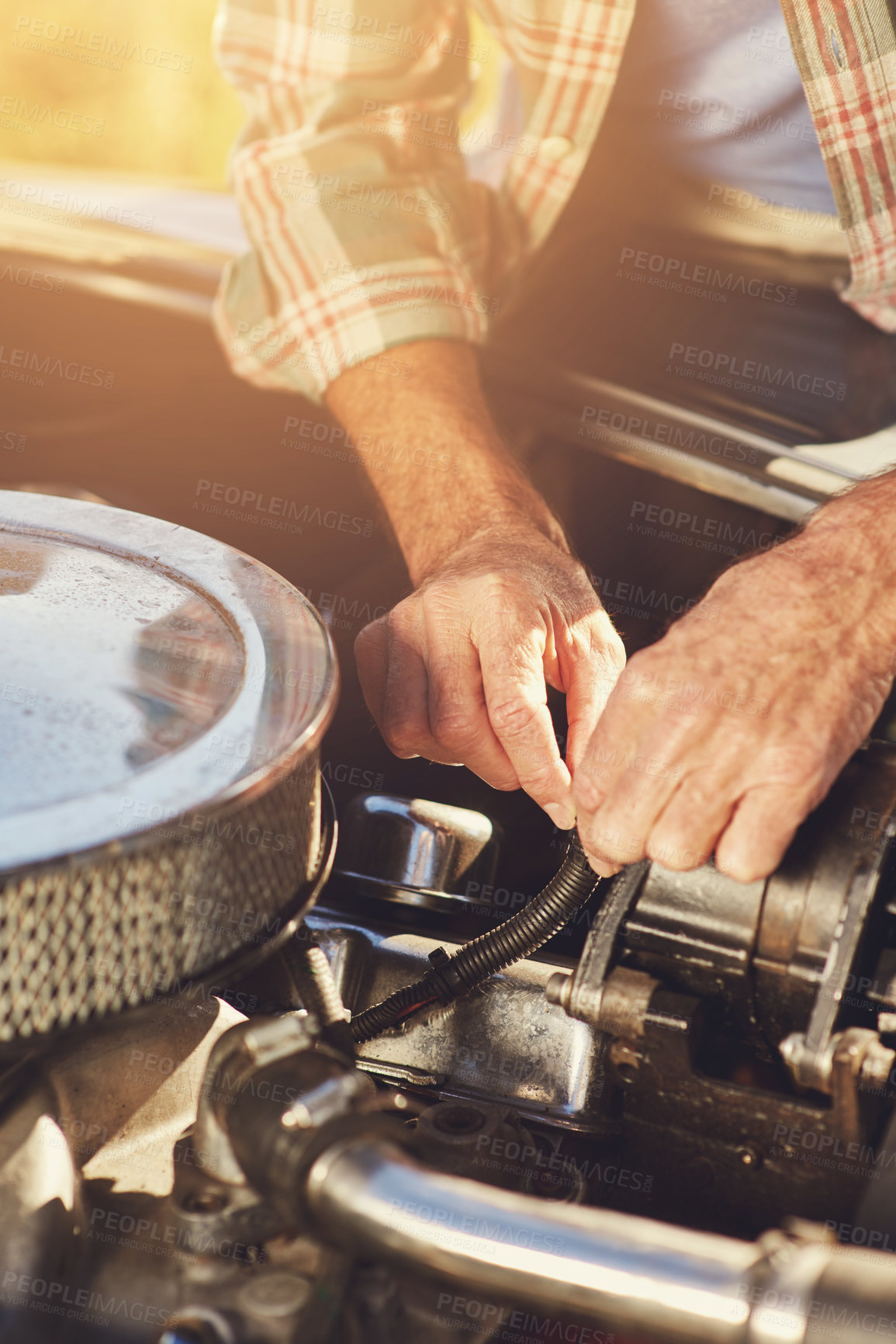 Buy stock photo Shot of a senior man looking under the hood of his car while on a roadtrip