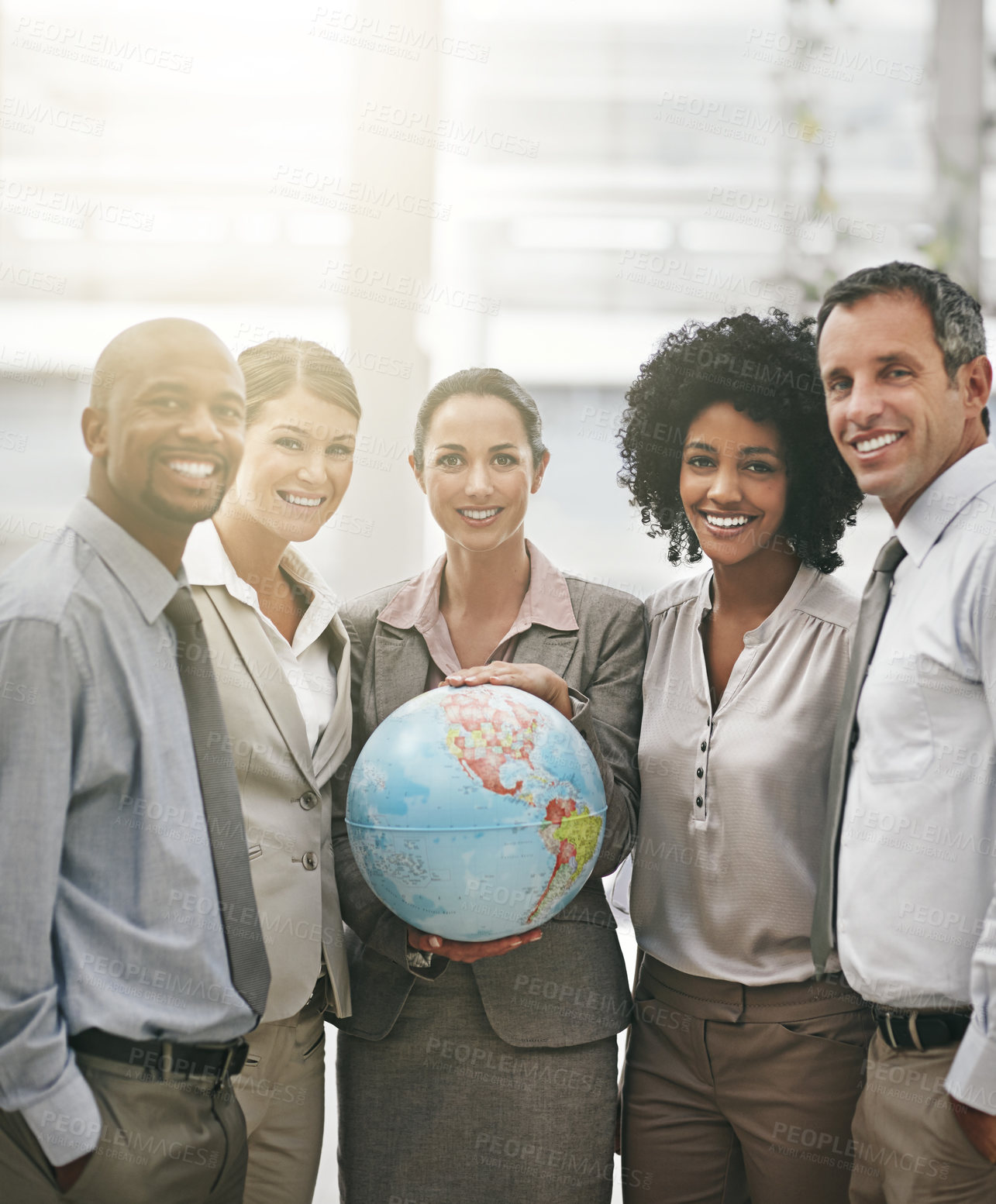 Buy stock photo Cropped portrait of a businesswoman holding a globe while standing with her colleagues