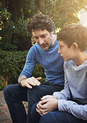Buy stock photo Shot of a father and son having a heart to heart in the backyard