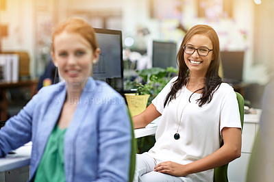 Buy stock photo Cropped portrait of two businesswomen sitting in the office
