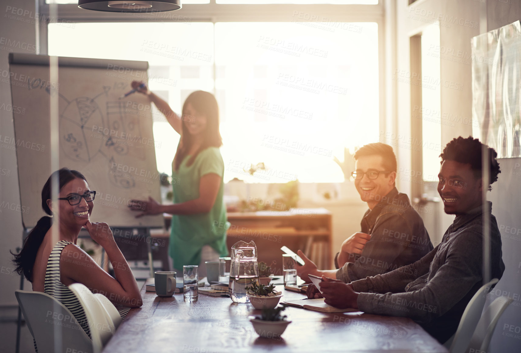 Buy stock photo Happy business woman leader writing on board explaining ideas and thoughts while brainstorming with colleagues. Portrait of diverse colleagues discussing ideas while collaborating on a project