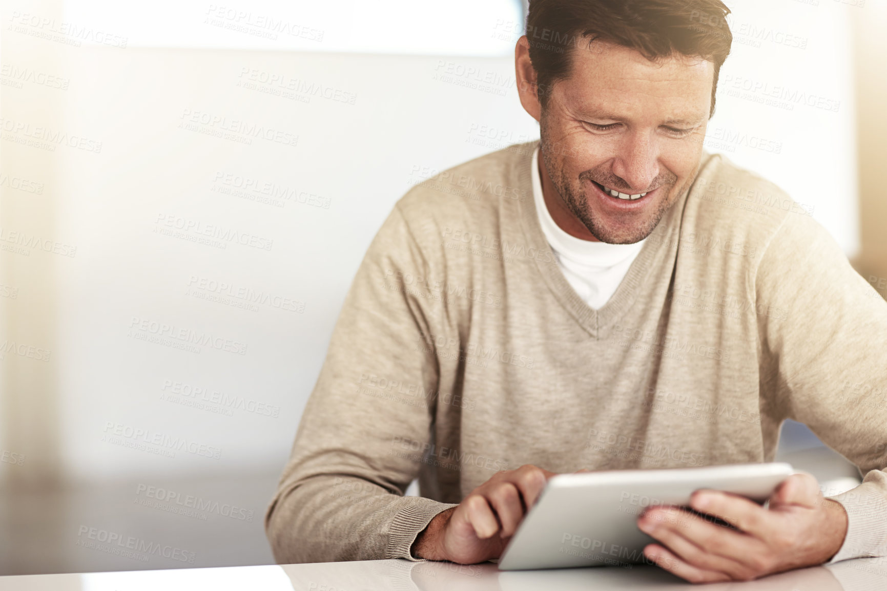 Buy stock photo Cropped shot of a man using his tablet at home