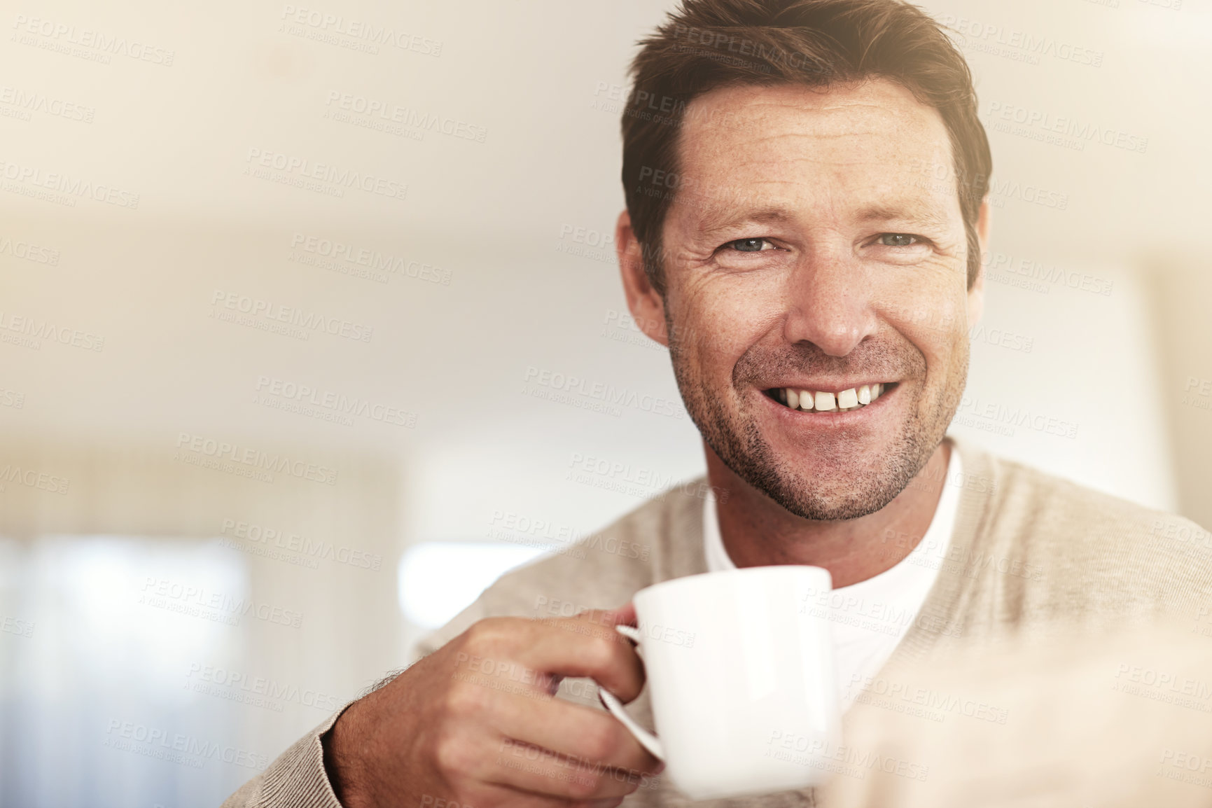 Buy stock photo Cropped portrait of a man drinking coffee while reading the paper at home